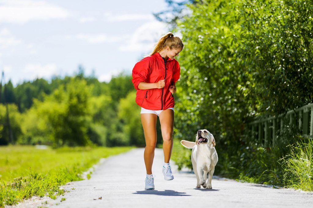 A woman sticking to active recovery with her dog.
