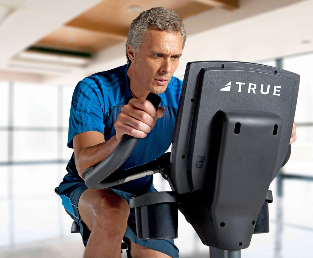 Older man working out on an indoor cycling bike
