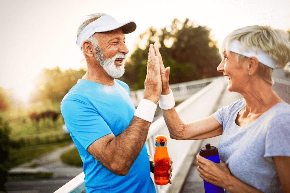 Joggers giving each other a high five. Safeguard Your Brain From Disease With Exercise.