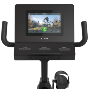 Close-up of the Performance Series Recumbent Bike’s console featuring a touchscreen cycling route, with handlebar grips on both sides and a pedal with foot strap visible below.