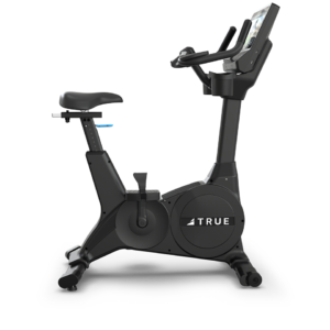 The Performance Series Upright Bike is a black stationary exercise bike featuring a padded seat, adjustable handlebars, a digital display, and the brand name TRUE on the circular side panel.