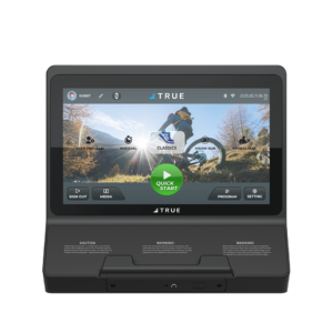 A close-up of a touchscreen fitness console displaying workout options, including classics, interval, vision run, and fitness test. The screen features a mountain scene background and a prominent green “Quick Start” button.